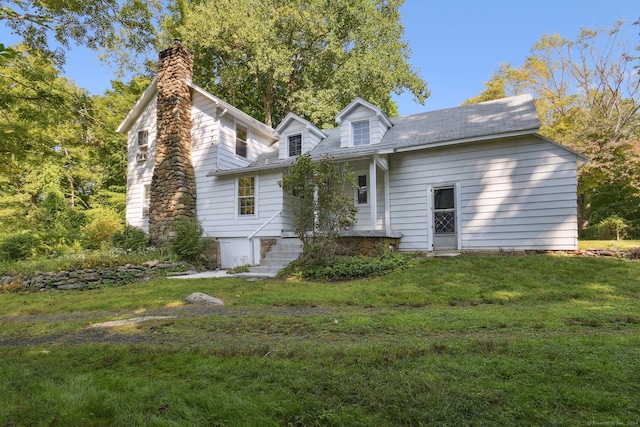 cape cod house featuring a front yard