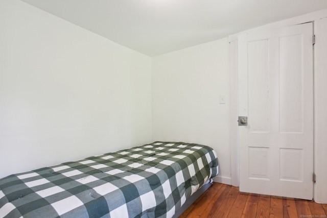 bedroom with dark wood-type flooring