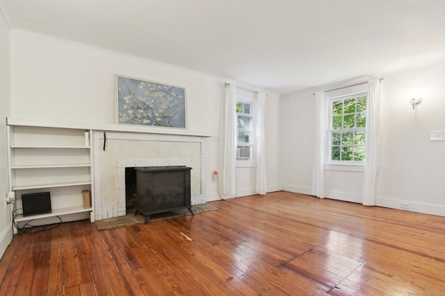 unfurnished living room featuring ornamental molding, wood-type flooring, and a fireplace