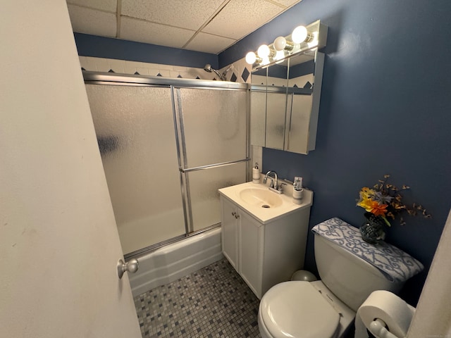 full bathroom with vanity, toilet, combined bath / shower with glass door, and a drop ceiling