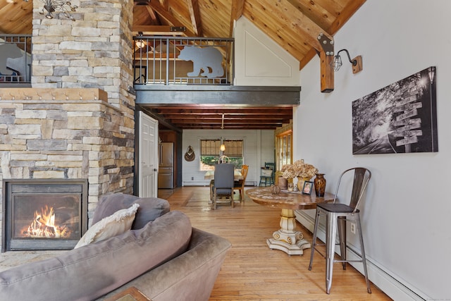 living room with beamed ceiling, a stone fireplace, high vaulted ceiling, and light hardwood / wood-style floors