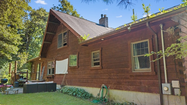 view of side of property featuring a yard and an outdoor hangout area