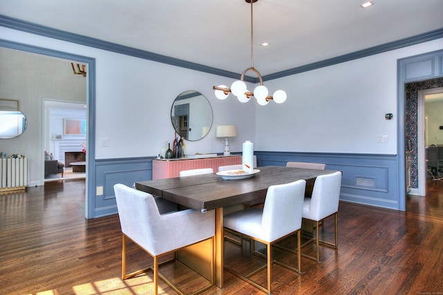 dining space with dark hardwood / wood-style floors, radiator heating unit, ornamental molding, and a fireplace