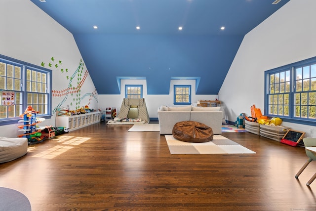 game room featuring high vaulted ceiling and dark wood-type flooring