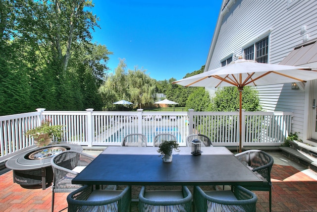 wooden terrace with a patio area and a fenced in pool