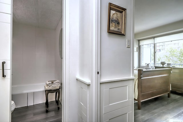 corridor featuring a textured ceiling and wood finished floors