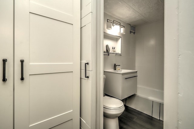 bathroom featuring toilet, vanity, and wood finished floors