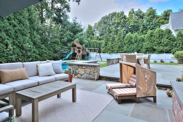 view of patio / terrace with outdoor lounge area, a playground, and a fenced backyard