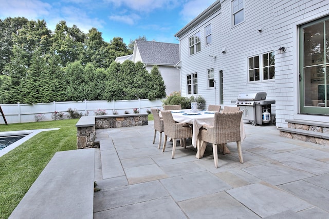 view of patio / terrace featuring outdoor dining space, fence, and a grill