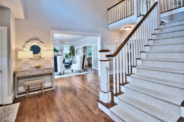 foyer entrance featuring stairway, wood finished floors, a high ceiling, and baseboards