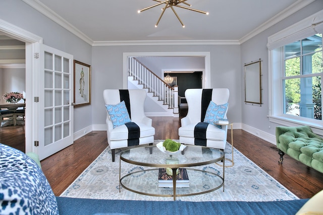 sitting room featuring a notable chandelier, crown molding, and wood finished floors