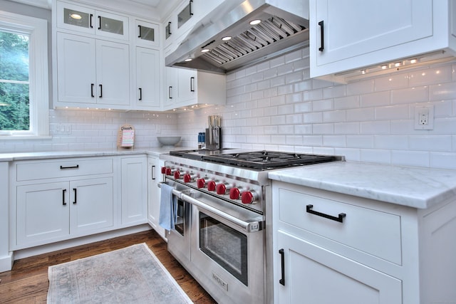 kitchen with double oven range, backsplash, white cabinets, extractor fan, and dark wood-style flooring