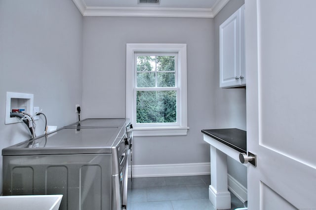 laundry room featuring cabinet space, independent washer and dryer, ornamental molding, and tile patterned flooring