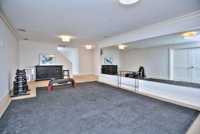 exercise room featuring crown molding, baseboards, and visible vents