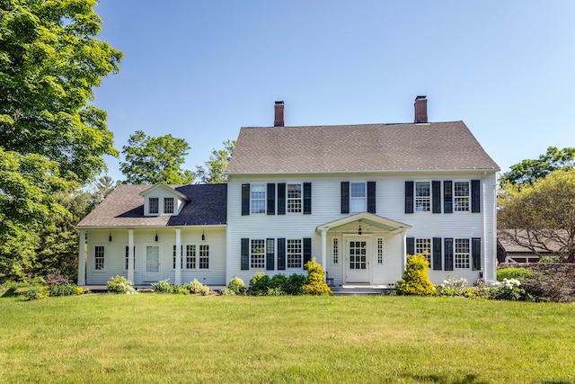 colonial inspired home featuring a front lawn