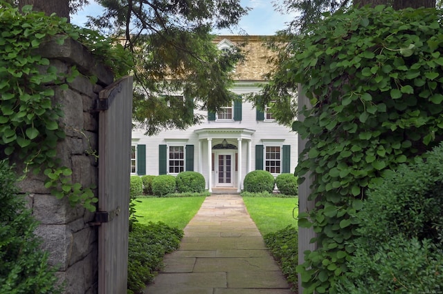 colonial inspired home featuring a front lawn