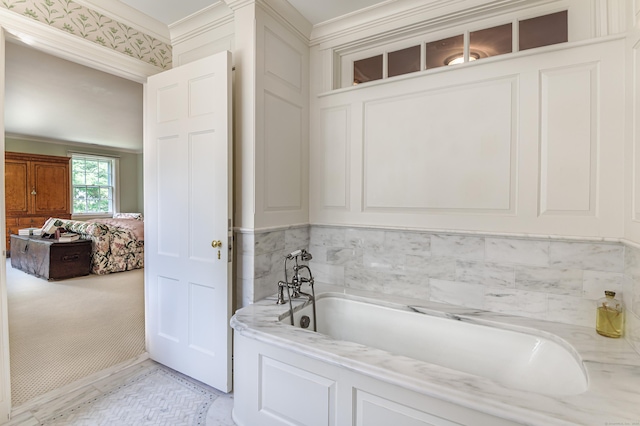 bathroom with a bath and ornamental molding