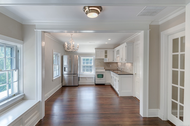 kitchen with a healthy amount of sunlight, stainless steel refrigerator with ice dispenser, and white stove