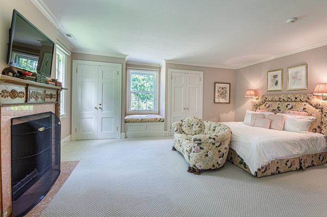 carpeted bedroom with a tiled fireplace and ornamental molding