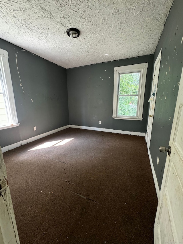 carpeted spare room featuring a textured ceiling