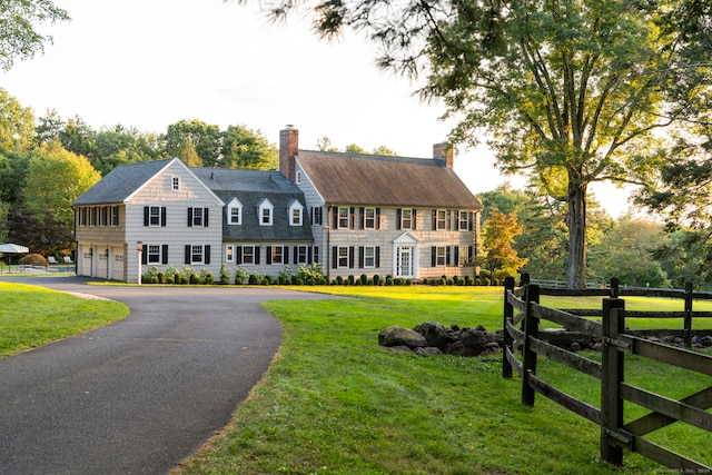 colonial house with a front lawn and a garage