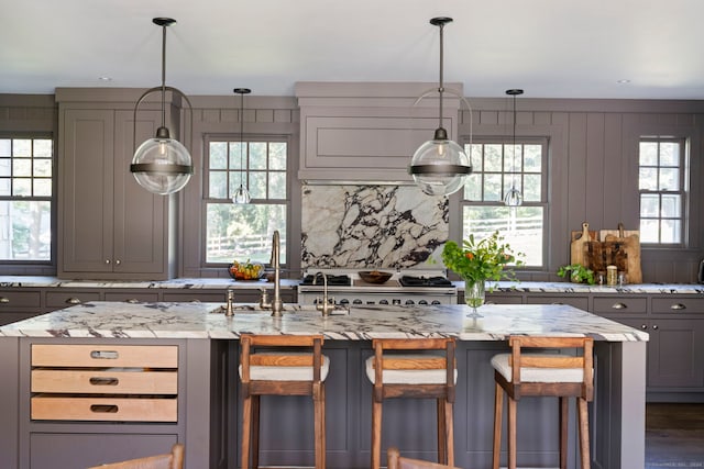 325 Old Mountain Rd, Farmington, CT 06032 - kitchen with gray cabinetry, light stone countertops, stainless steel range, and a kitchen breakfast bar