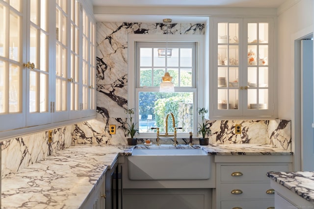 325 Old Mountain Rd, Farmington, CT 06032 - kitchen featuring a sink, tasteful backsplash, glass insert cabinets, and light stone countertops