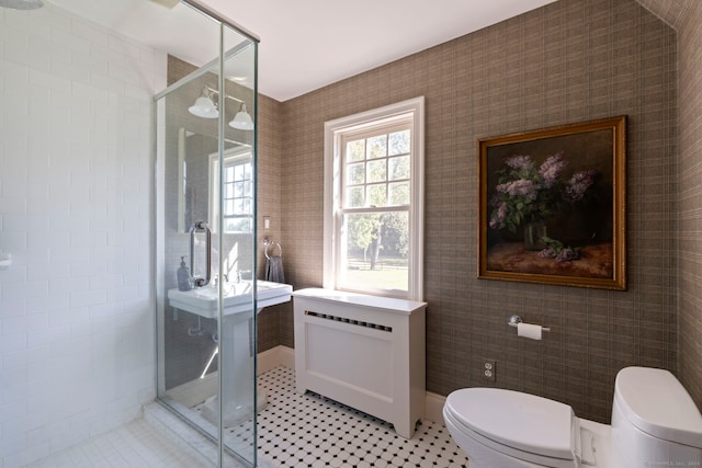 bathroom with a shower with door, tile patterned floors, and toilet