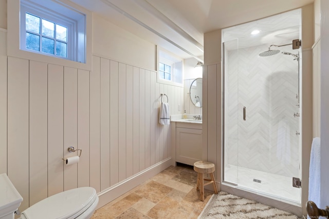 bathroom featuring vanity, a shower with shower door, toilet, and wood walls