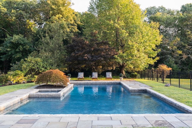 view of swimming pool featuring an in ground hot tub and a yard