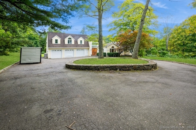 cape cod house with a front lawn and a garage