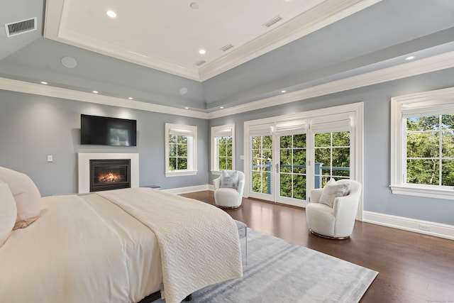 bedroom with ornamental molding, a raised ceiling, and dark hardwood / wood-style flooring