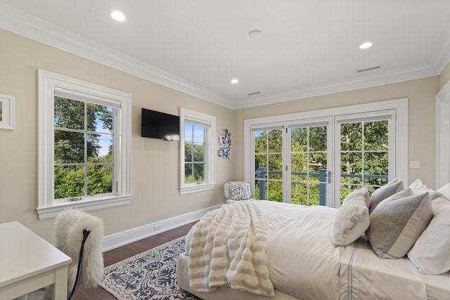 bedroom with ornamental molding, multiple windows, and hardwood / wood-style flooring