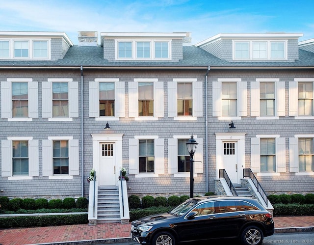 townhome / multi-family property with a shingled roof