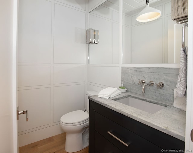 bathroom with vanity, toilet, and hardwood / wood-style floors