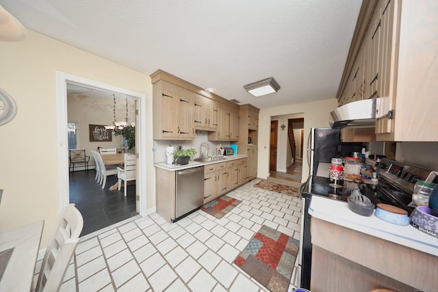 kitchen featuring a textured ceiling, appliances with stainless steel finishes, light brown cabinetry, and sink