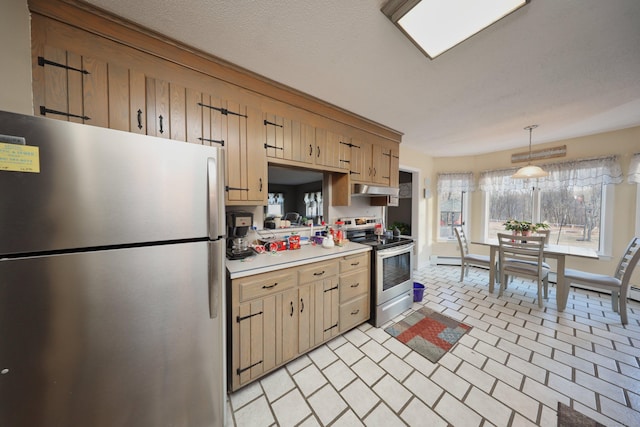 kitchen with a textured ceiling, stainless steel appliances, and hanging light fixtures