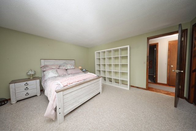 bedroom with a textured ceiling and light colored carpet