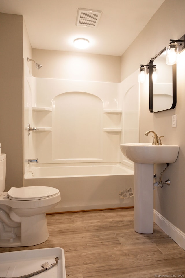 bathroom featuring shower / bath combination, toilet, and hardwood / wood-style flooring