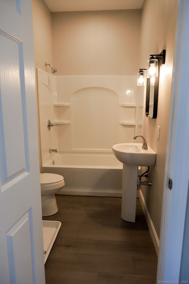 bathroom with wood-type flooring, toilet, and shower / washtub combination