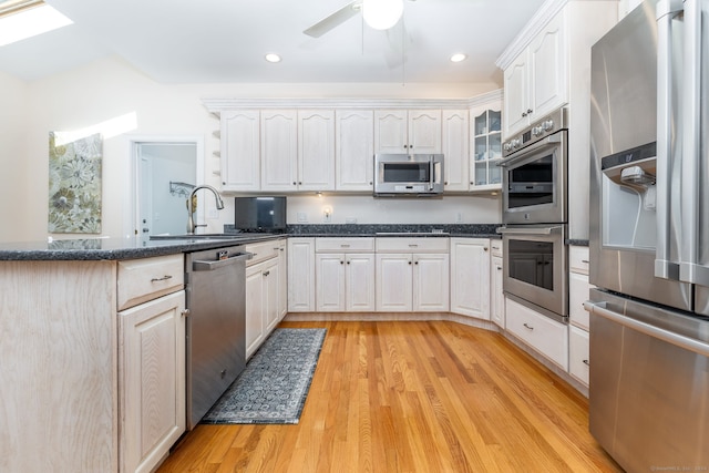 kitchen featuring white cabinetry, kitchen peninsula, stainless steel appliances, and light hardwood / wood-style flooring