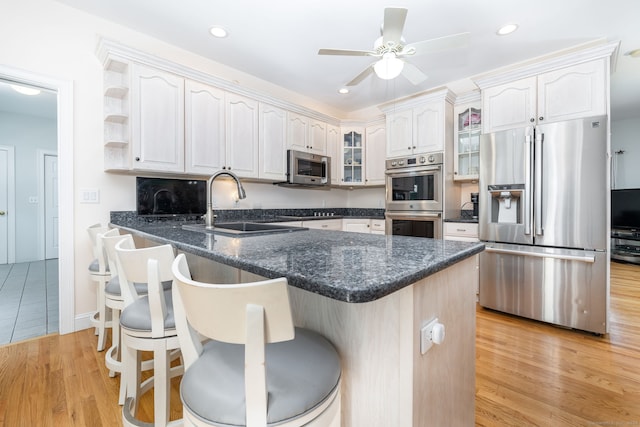 kitchen with a kitchen breakfast bar, light wood-type flooring, and stainless steel appliances