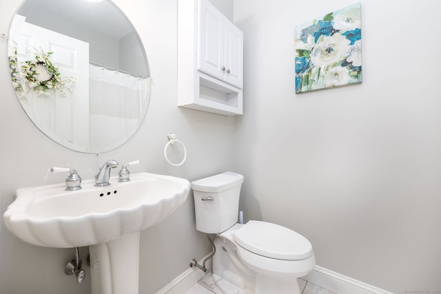 bathroom featuring tile patterned floors, toilet, and sink