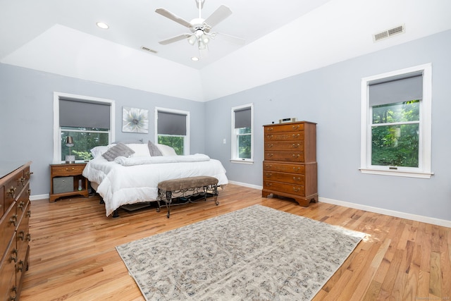 bedroom featuring ceiling fan, light hardwood / wood-style floors, and a raised ceiling