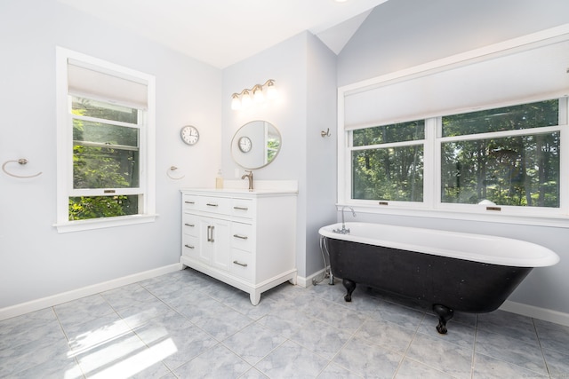 bathroom featuring vanity, a bathtub, and lofted ceiling