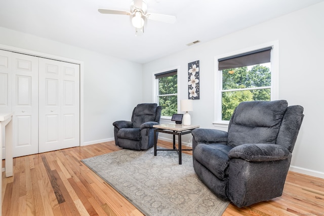 living area featuring wood-type flooring and ceiling fan