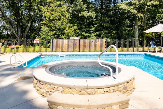 view of pool featuring an in ground hot tub