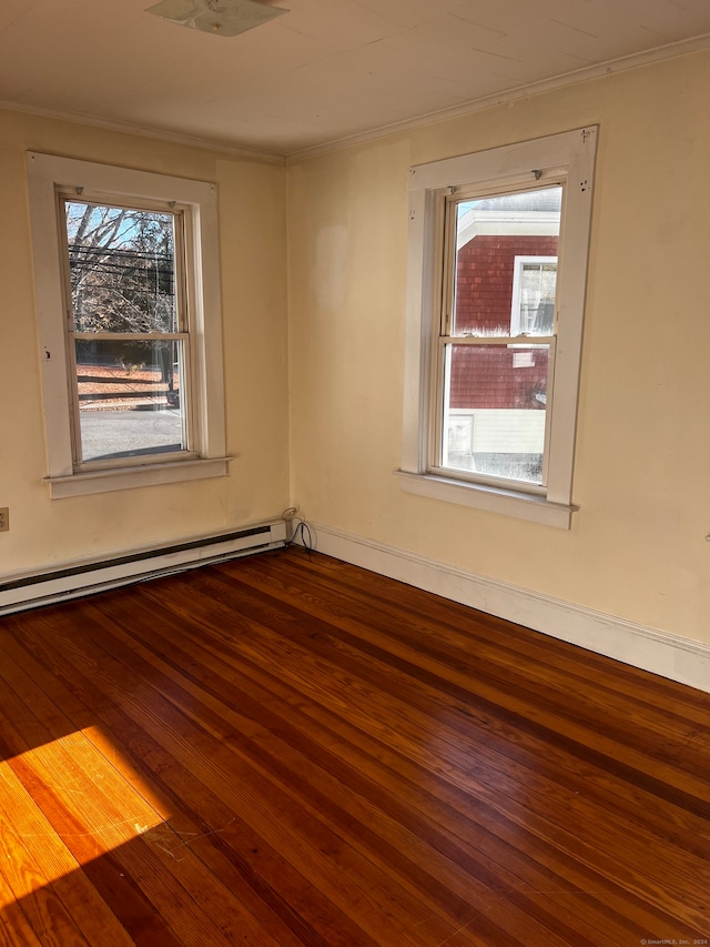 unfurnished room with ornamental molding, a baseboard heating unit, and wood-type flooring