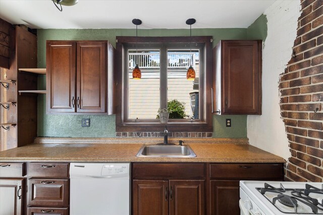 kitchen with pendant lighting, white appliances, brick wall, and sink