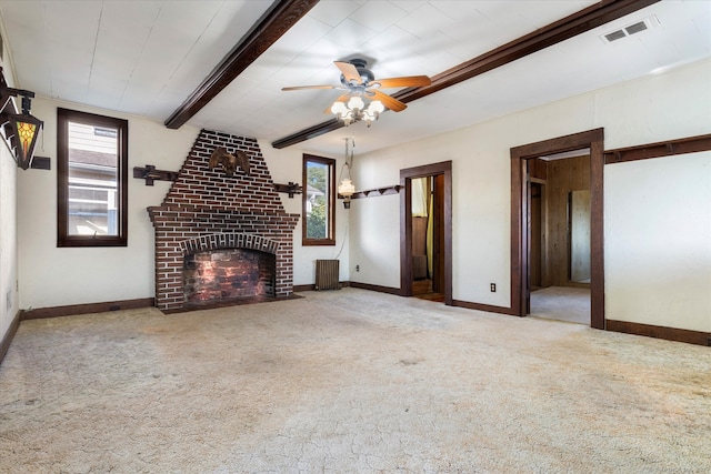 unfurnished living room with ceiling fan, carpet, beamed ceiling, and a brick fireplace